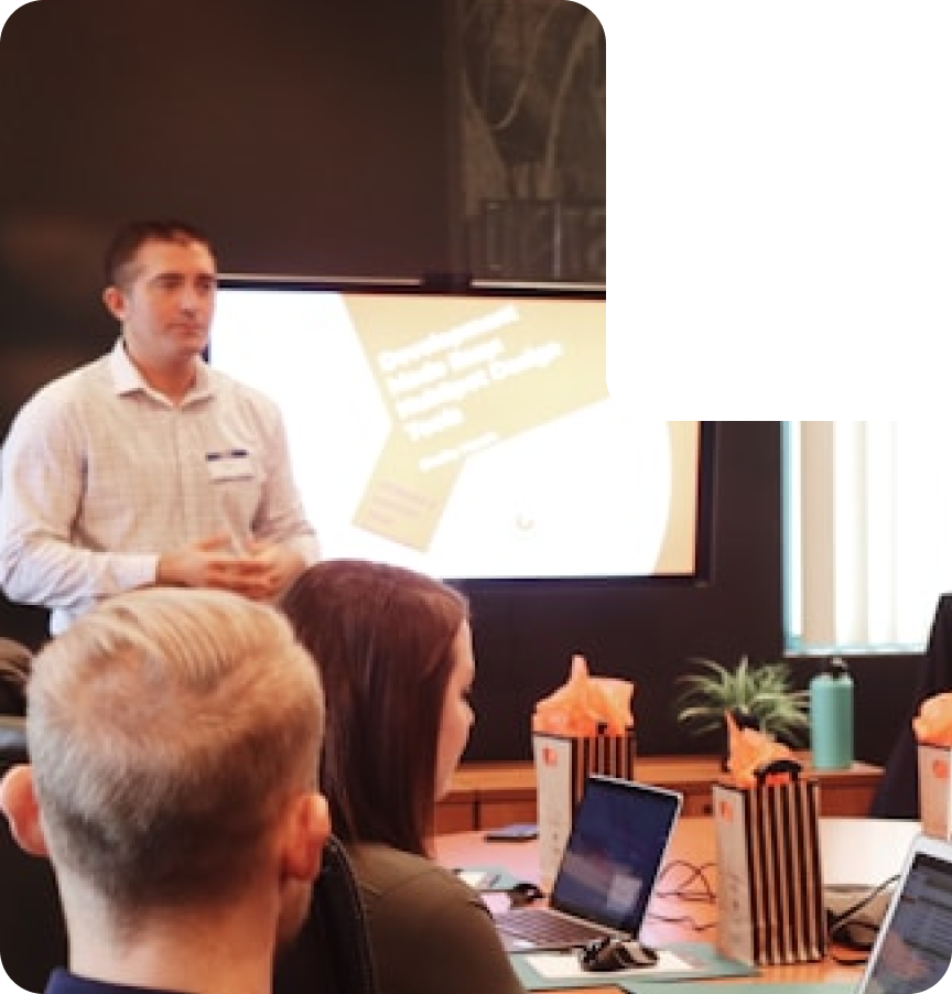 A man presenting to a group of people in a meeting room